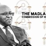 Brown Mogotsi giving testimony at the Madlanga Commission, gesturing while speaking, with legal representatives and commission officials in the background.